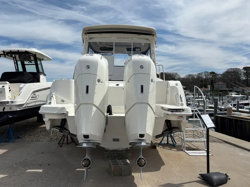 Slide: The Image of 2025 Boston Whaler 365 Conquest boat with dual engines docked at marina. - 2