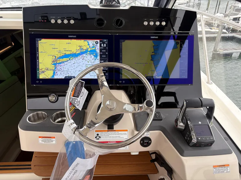 Slide: The Image of 2025 Boston Whaler 365 Conquest helm with dual navigation screens and steering wheel. - 23