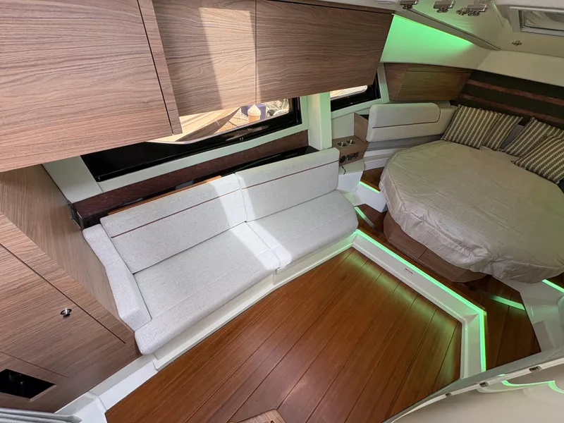 Slide: The Image of 2025 Boston Whaler 365 Conquest cabin with modern interior, wood flooring, and ambient lighting. - 27