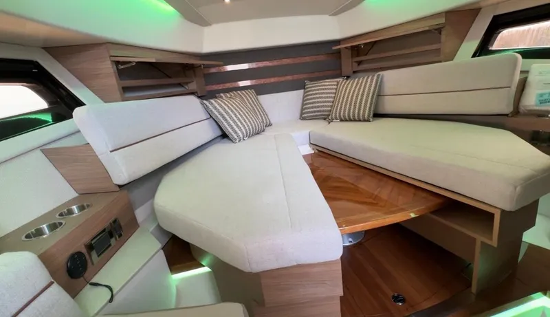 Slide: The Image of 2025 Boston Whaler 365 Conquest cabin interior with cushioned seating and striped pillows. - 30