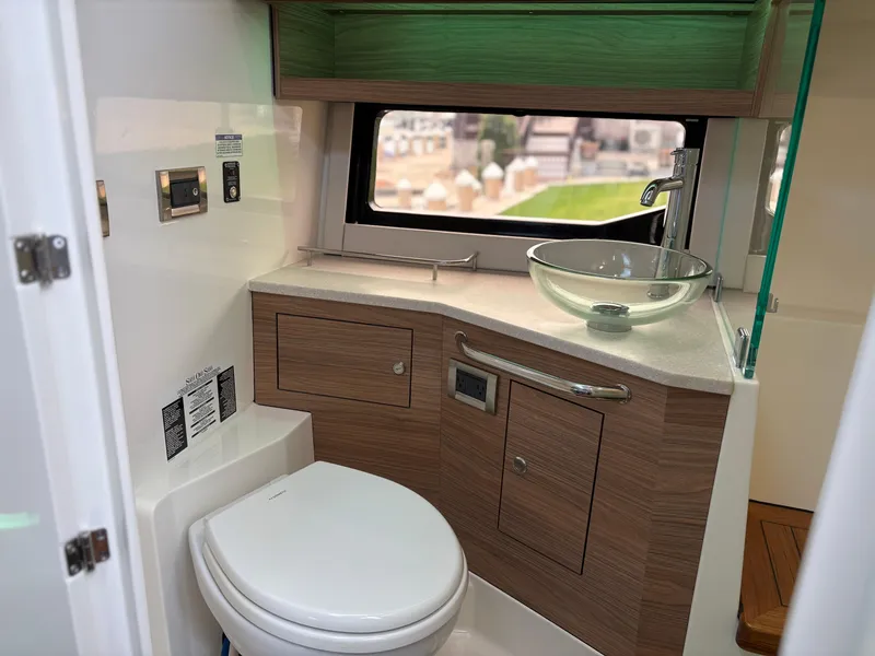 Slide: The Image of Modern bathroom in 2025 Boston Whaler 365 Conquest boat with sleek fixtures and wood accents. - 31