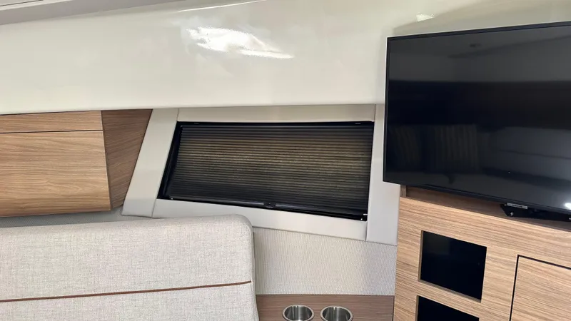Slide: The Image of 2025 Boston Whaler 365 Conquest interior with modern wood finish and flat-screen TV. - 36