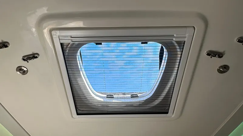 Slide: The Image of 2025 Boston Whaler 365 Conquest cabin skylight with open view of blue sky. - 39