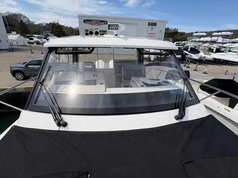 Slide: The Image of 2025 Boston Whaler 365 Conquest boat, docked with covered bow, clear windshield, and marina background. - 41