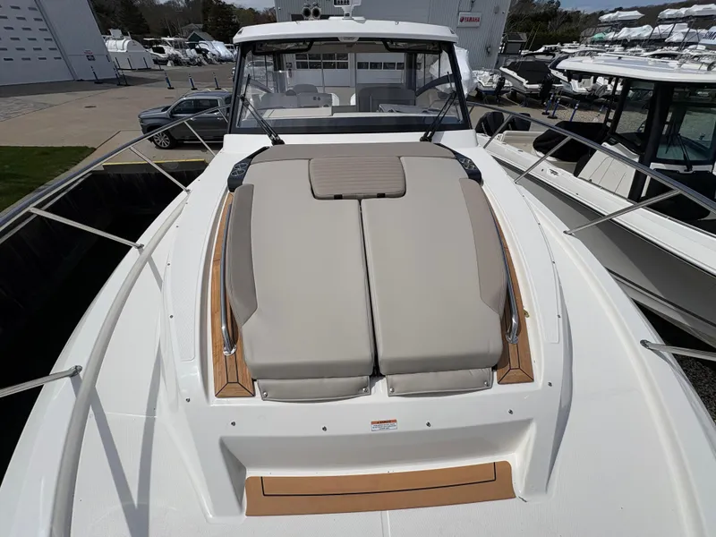 Slide: The Image of 2025 Boston Whaler 365 Conquest boat with cushioned deck seating, docked at marina. - 42
