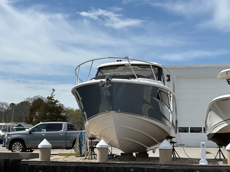 Slide: The Image of 2025 Boston Whaler 365 Conquest boat on display at a marina, clear sky background. - 44