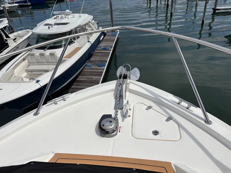 Slide: The Image of 2025 Boston Whaler 365 Conquest bow view at marina, showcasing sleek design and anchor system. - 45