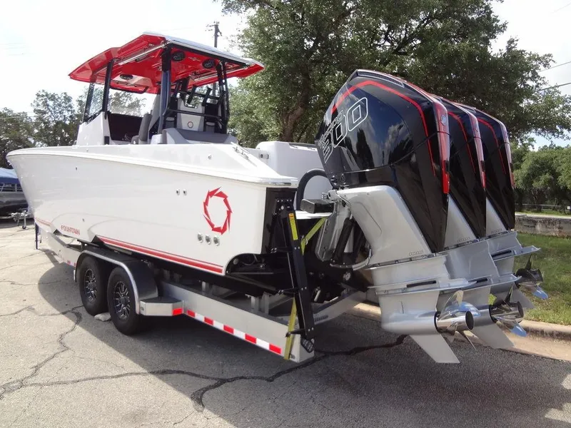 Slide: The Image of 2024 Fountain 32NX boat on trailer with triple outboard engines. - 10