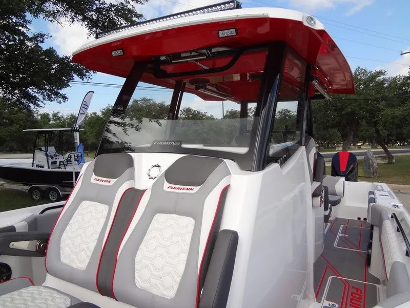 Slide: The Image of 2024 Fountain 32NX boat with red and white seating and canopy. - 19