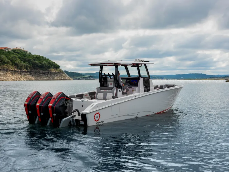 Slide: The Image of 2024 Fountain 32NX boat with triple engines on a calm lake. - 2