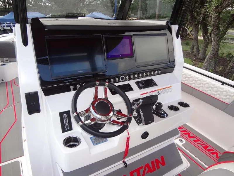 Slide: The Image of 2024 Fountain 32NX boat dashboard with steering wheel and electronic displays. - 22