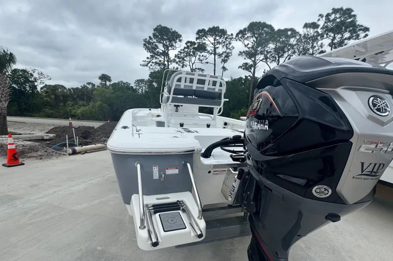 Slide: The Image of 2024 NauticStar 224 Bay boat with Yamaha engine, parked outdoors on a cloudy day. - 12