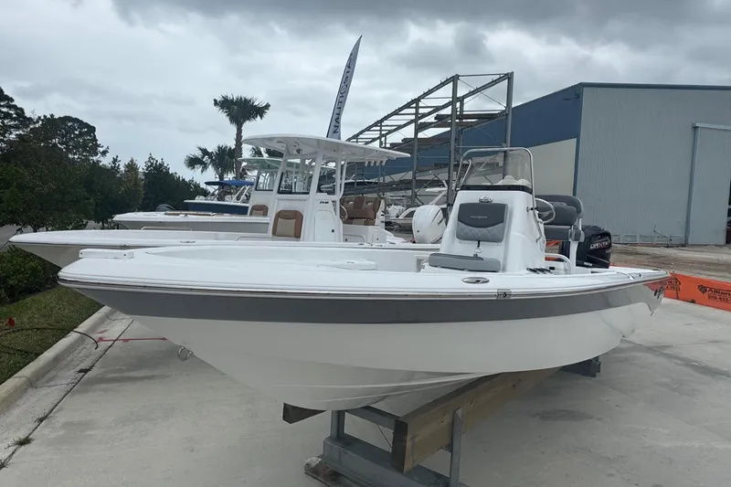 Slide: The Image of 2024 NauticStar 224 Bay boat displayed outdoors on a cloudy day. - 13
