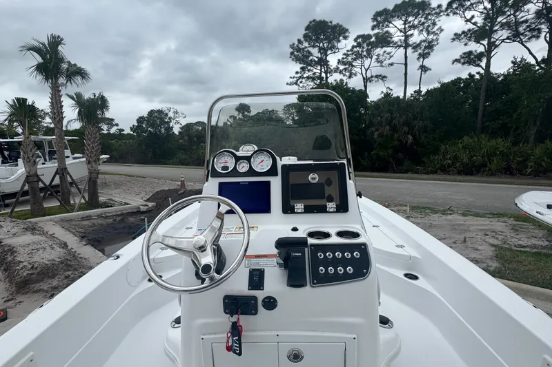 Slide: The Image of 2024 NauticStar 224 Bay boat dashboard with steering wheel and control panel. - 14