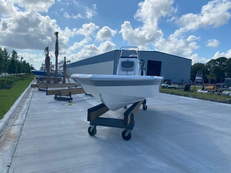 Slide: The Image of 2024 NauticStar 224 Bay boat on a trailer outside a warehouse. - 6