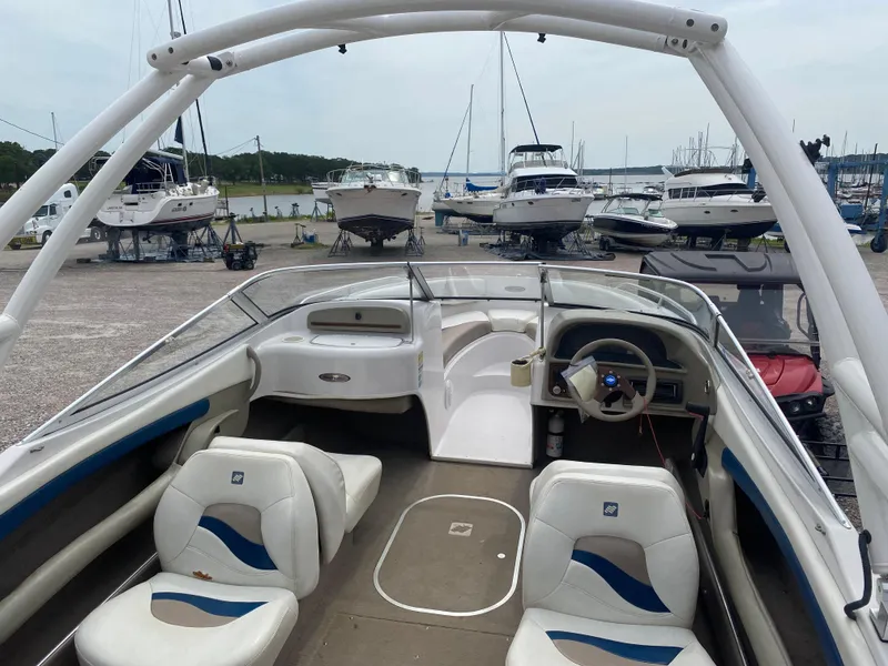 Slide: The Image of 1997 Four Winns 200 Horizon boat interior with white and blue seating, docked at a marina. - 11
