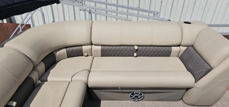 Slide: The Image of 2024 Sun Tracker Party Barge 20 DLX with beige cushioned seating and storage compartment. - 12