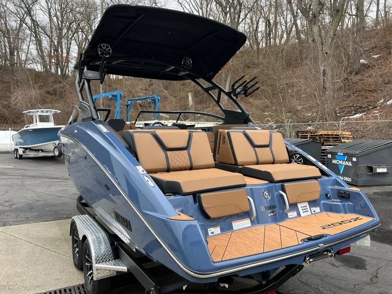 Slide: The Image of 2024 Yamaha Boats 255XD, blue, luxury seating, on trailer, outdoor setting. - 12