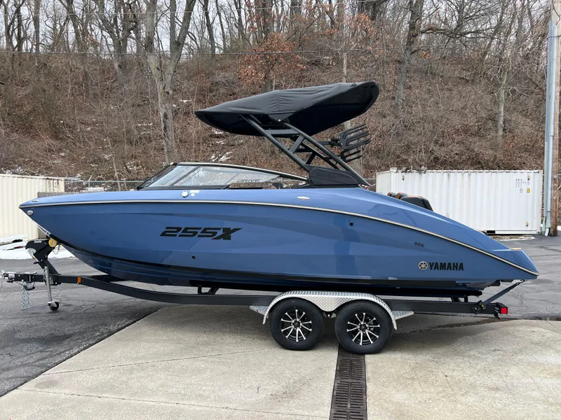 Slide: The Image of 2024 Yamaha Boats 255XD in blue, parked on a trailer. - 13