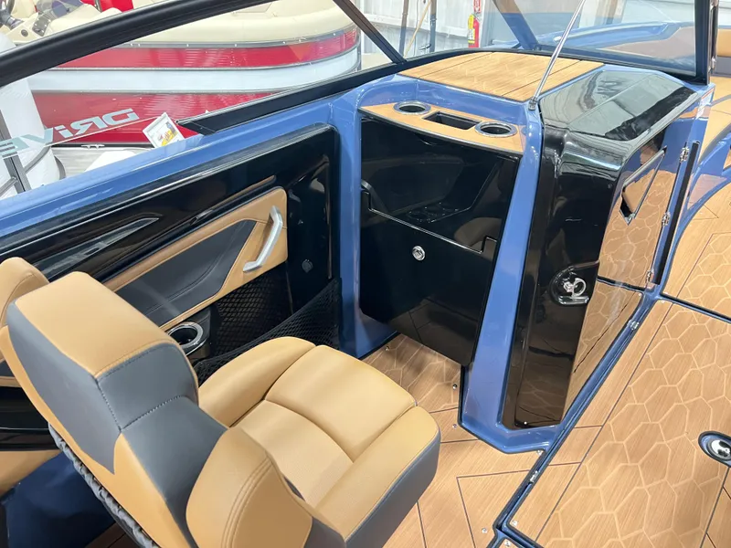 Slide: The Image of 2024 Yamaha Boats 255XD interior with tan and black seating, modern dashboard, and storage compartments. - 8