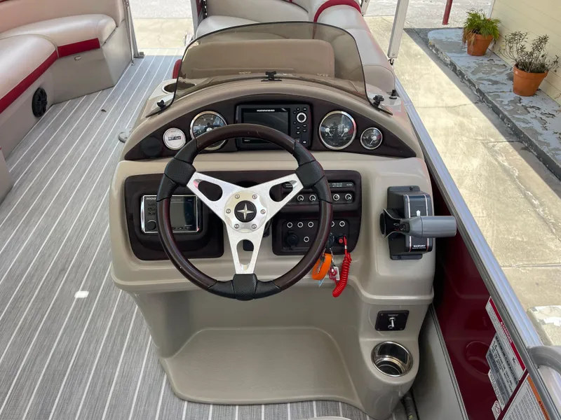 Slide: The Image of 2018 Berkshire 250E STS boat dashboard with steering wheel and control panel. - 13