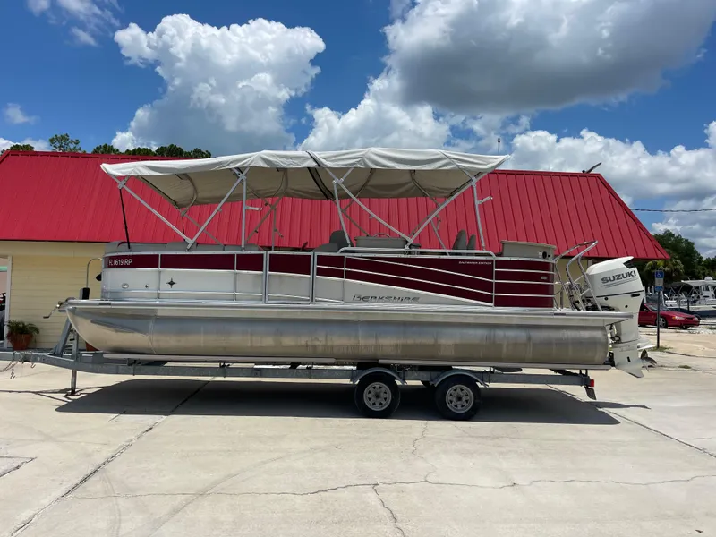 The Image of 2018 Berkshire 250E STS pontoon boat on trailer with red and white exterior. - 2