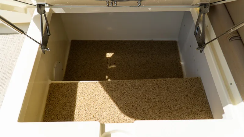 Slide: The Image of Storage compartment of 2025 Chris-Craft 32 Calypso boat, open with carpeted interior. - 16