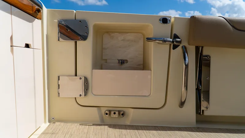 Slide: The Image of 2025 Chris-Craft 32 Calypso boat interior detail with storage compartment and railing. - 23