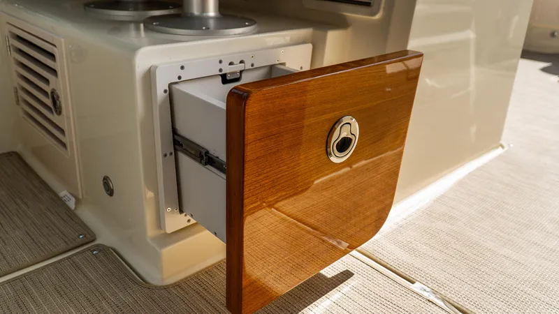 Slide: The Image of 2025 Chris-Craft 32 Calypso boat with open wooden storage compartment. - 30