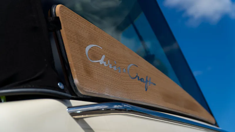 Slide: The Image of 2025 Chris-Craft 32 Calypso boat detail with logo on wooden panel. - 4