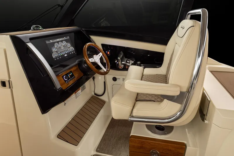 Slide: The Image of 2025 Chris-Craft 32 Calypso helm station with luxurious captain's chair and advanced navigation system. - 61