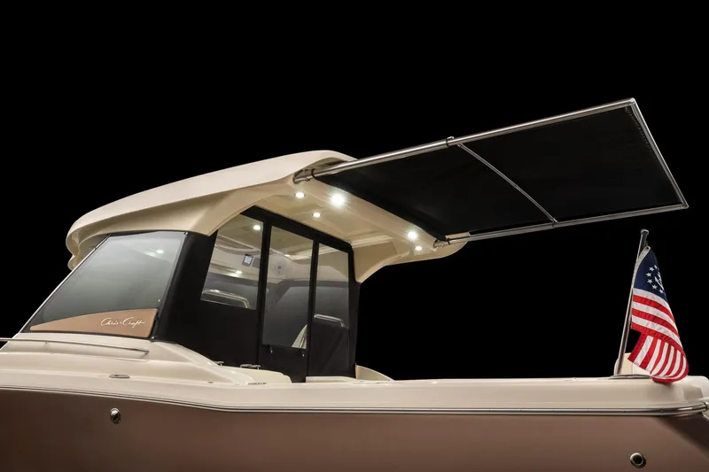 Slide: The Image of 2025 Chris-Craft 32 Calypso boat with extended sunshade and American flag. - 65