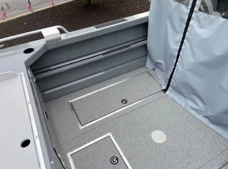 Slide: The Image of 2024 Spartan 200 Astoria boat interior with storage compartments and protective cover. - 9
