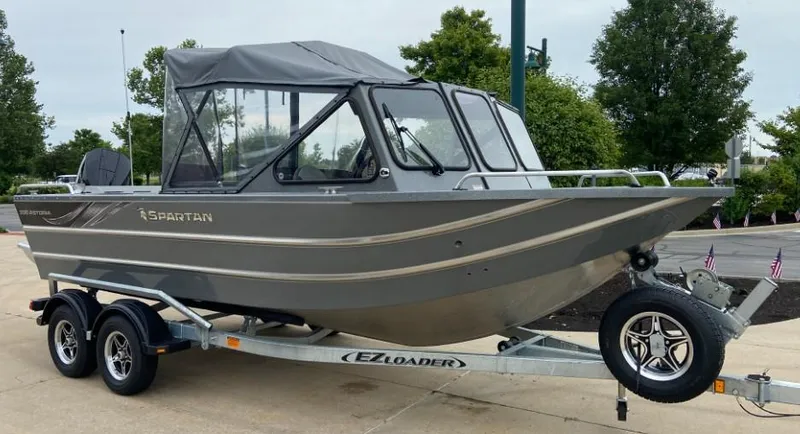 The Image of 2024 Spartan 200 Astoria boat on EZ Loader trailer, parked outdoors. - 0