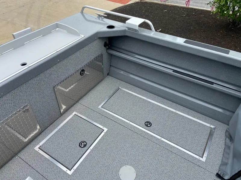 Slide: The Image of 2024 Spartan 200 Astoria boat interior with storage compartments and diamond plate accents. - 12