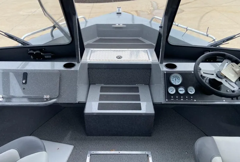 Slide: The Image of 2023 Spartan 215 Athens boat interior with steering wheel and dashboard. - 10