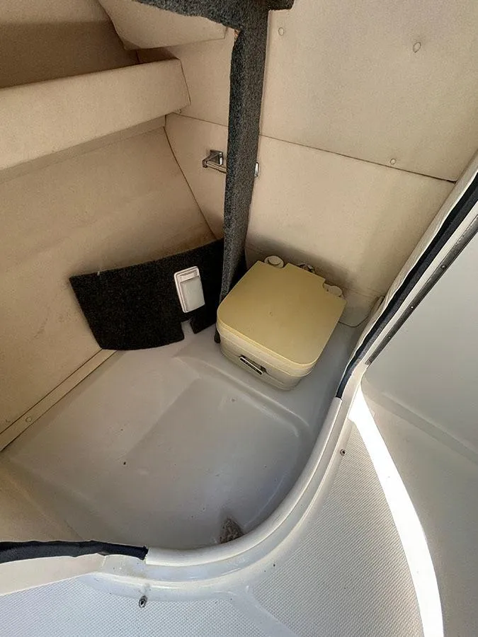 Slide: The Image of 2007 Sea Ray 220 Sundeck interior cabin with portable toilet. - 10