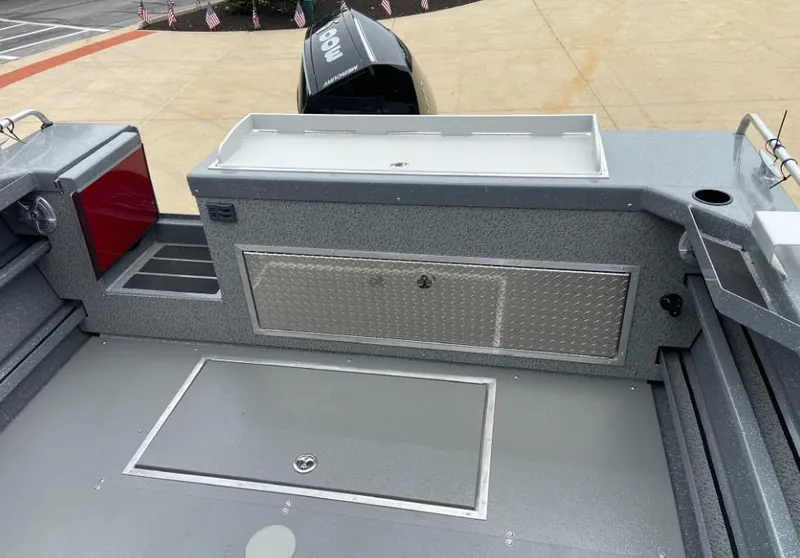 Slide: The Image of 2024 Spartan 240 MAXIMUS PRO XL boat deck with storage compartments and motor. - 11