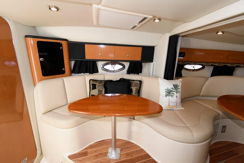 Slide: The Image of 2010 Chaparral Signature 350 cabin interior with leather seating and wooden table. - 18