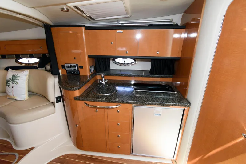 Slide: The Image of Chaparral Signature 350 2010 boat interior kitchen with wooden cabinets and granite countertop. - 19