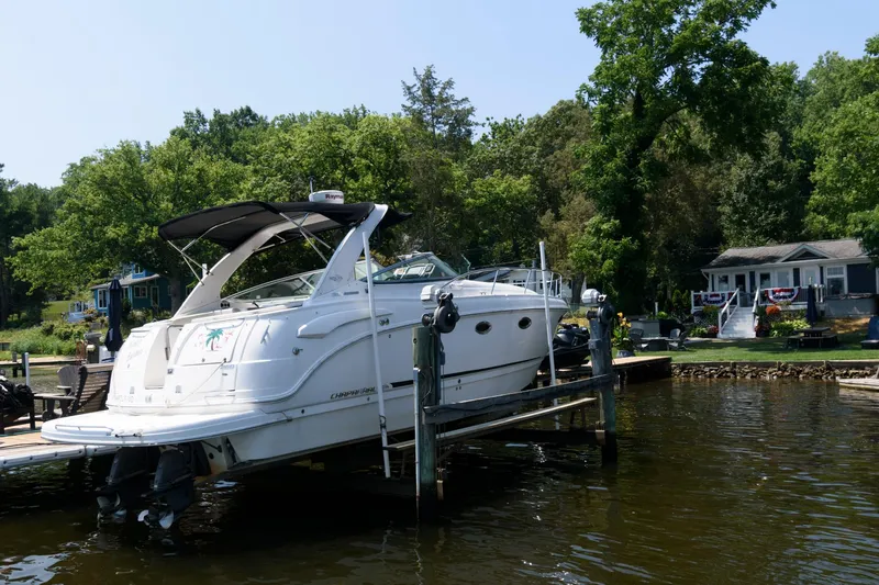 Slide: The Image of 2010 Chaparral Signature 350 boat docked by a lakeside cabin. - 3