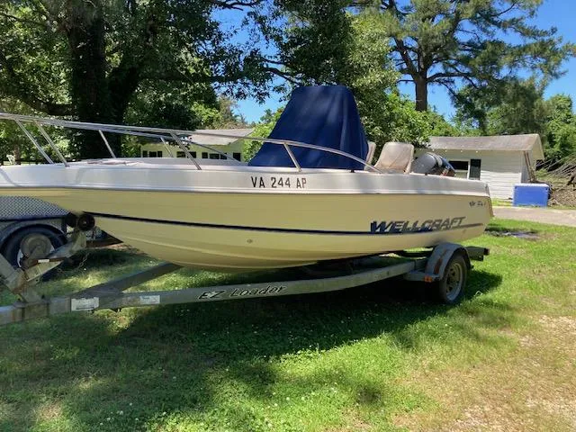 Slide: The Image of 1999 Wellcraft 190 CC F boat on trailer in grassy yard. - 4