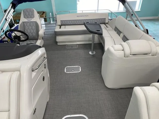 Slide: The Image of 2024 Bennington 25 QSB X1 boat helm with steering wheel, control panel, and seating. - 12