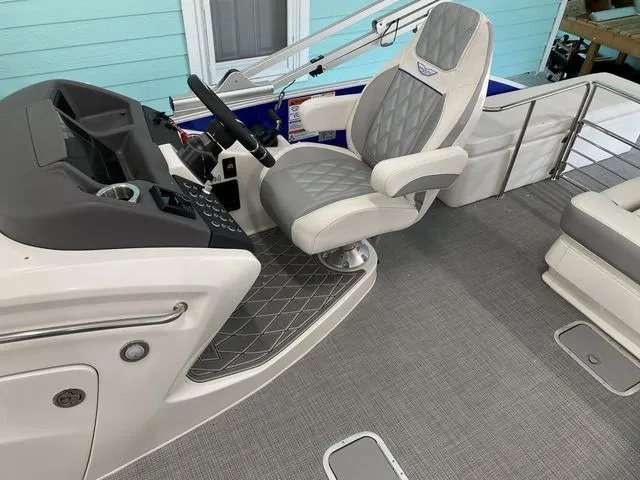 Slide: The Image of 2024 Bennington 25 QSB X1 boat interior with white cushioned seating and stainless steel railings. - 16