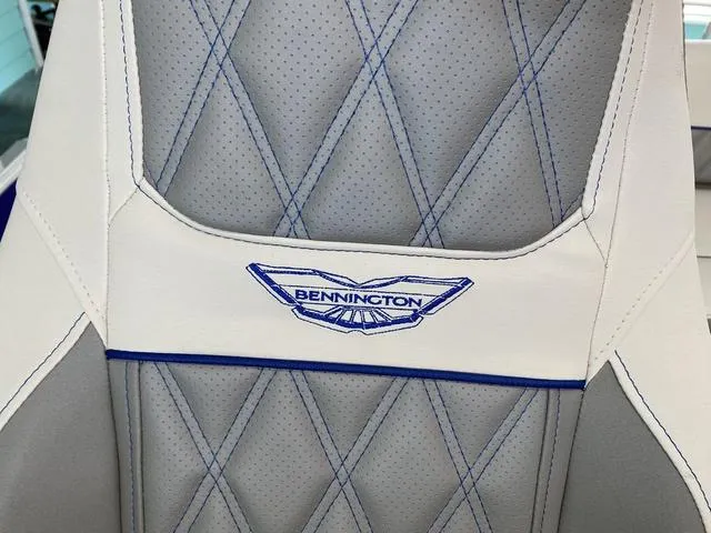 Slide: The Image of Bennington 25 QSB X1 2024 boat seat with blue stitching and logo. - 24