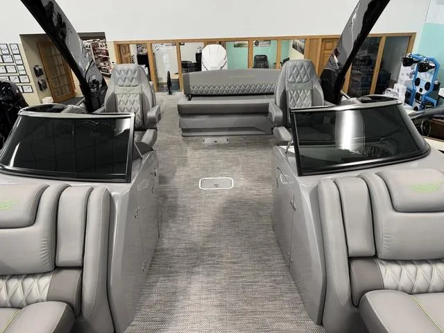 Slide: The Image of 2024 Bennington 28 QXSBWA X1 boat interior seating with gray upholstery and green accents. - 11