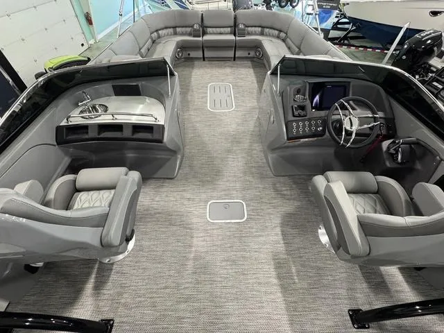 Slide: The Image of 2024 Bennington 28 QXSBWA X1 boat interior with gray seating and yellow boat in background. - 13