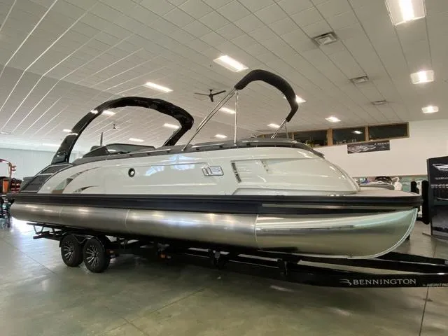 Slide: The Image of 2024 Bennington 28 QXSBWA X1 pontoon boat displayed indoors on a trailer. - 24