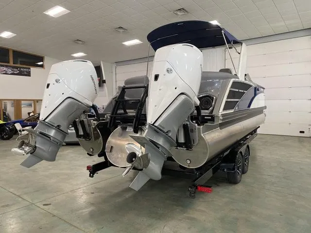 Slide: The Image of 2023 Bennington 27 RXFBWA T2 pontoon boat with dual outboard motors in a showroom. - 19