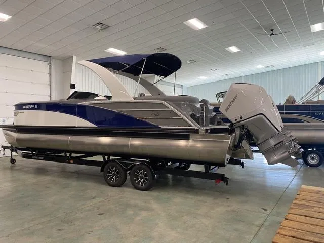 Slide: The Image of 2023 Bennington 27 RXFBWA T2 pontoon boat with dual outboard motors in showroom. - 3